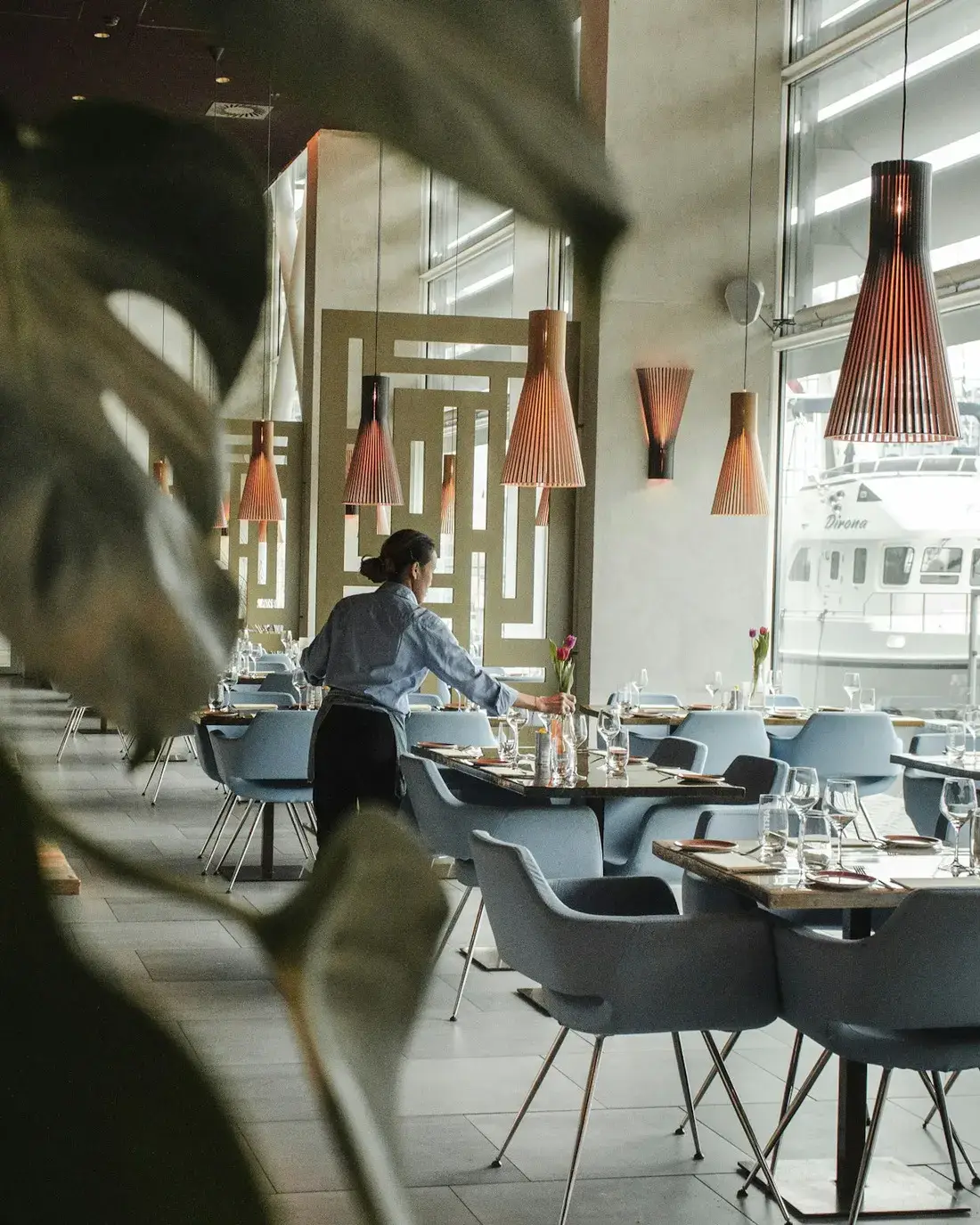 Medewerker die een tafel klaarzet in de zaal van een restaurant